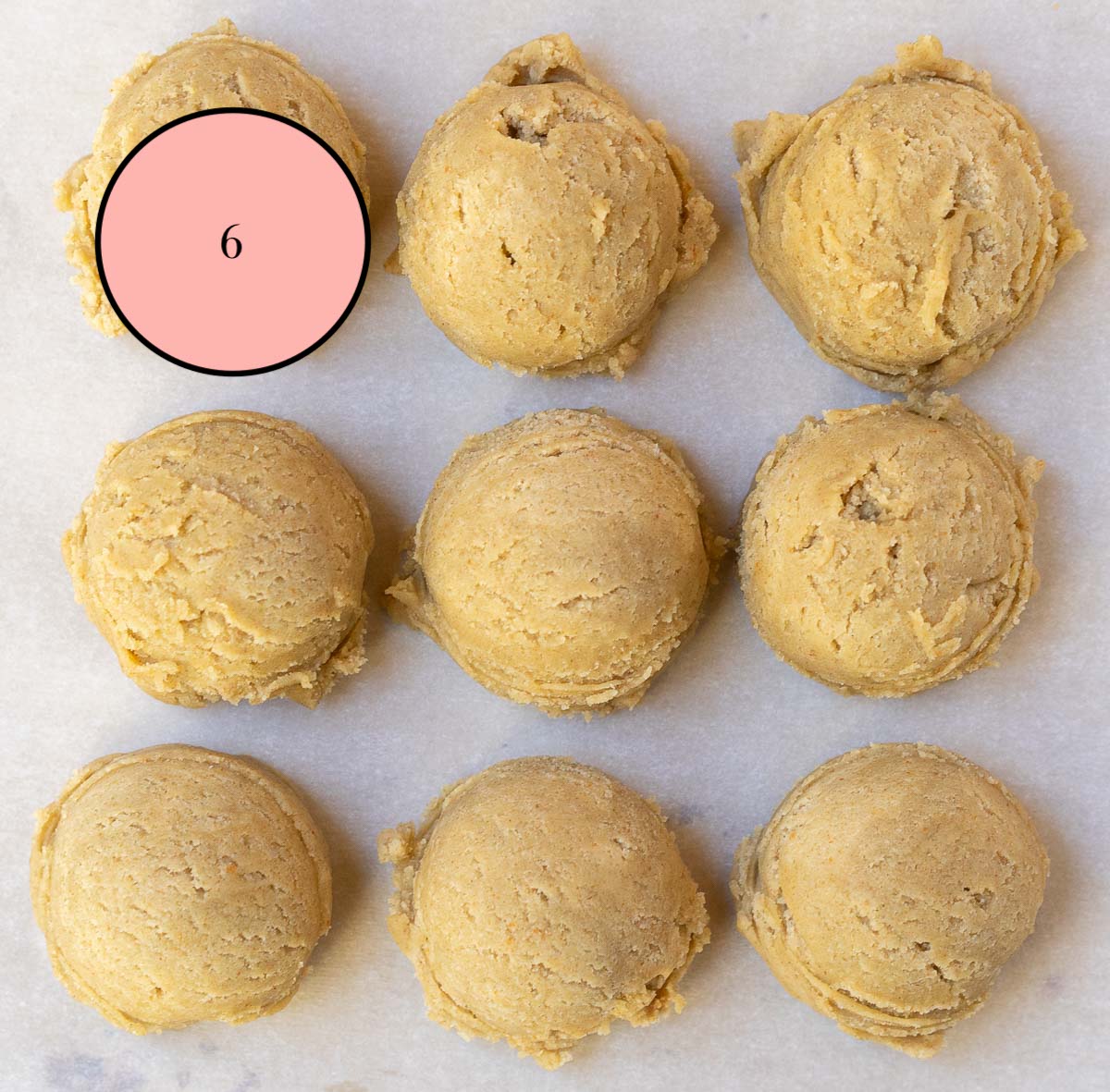 scooped balls of chipless dough sitting on baking sheet