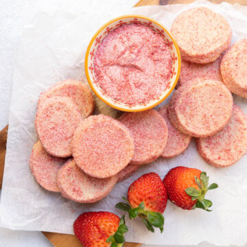 strawberry shortbread cookies spread out on cutting board.