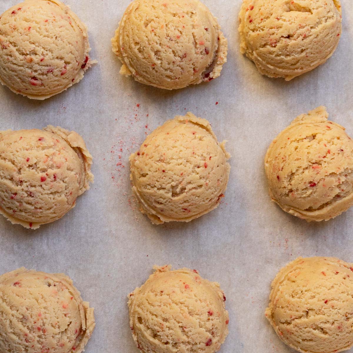 strawberry sugar cookie dough scooped on baking sheet.