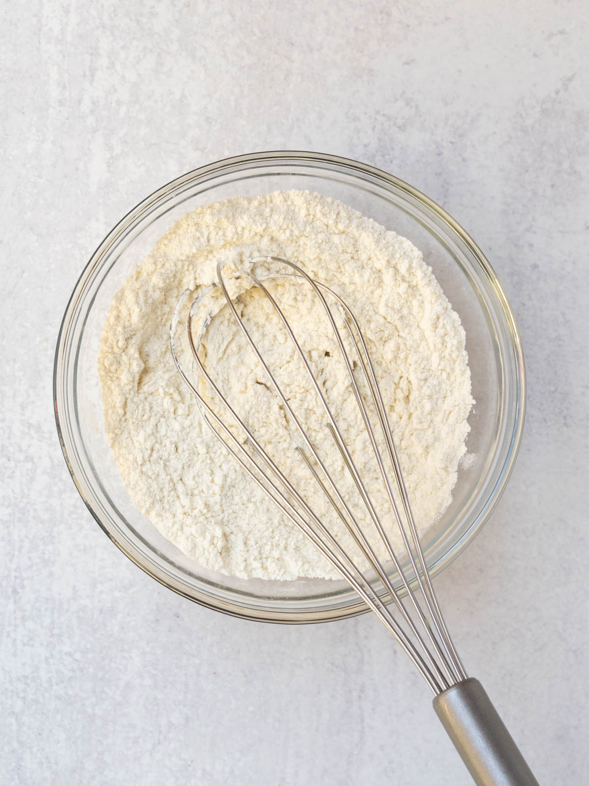 dry ingredients in mixing bowl being whisked.