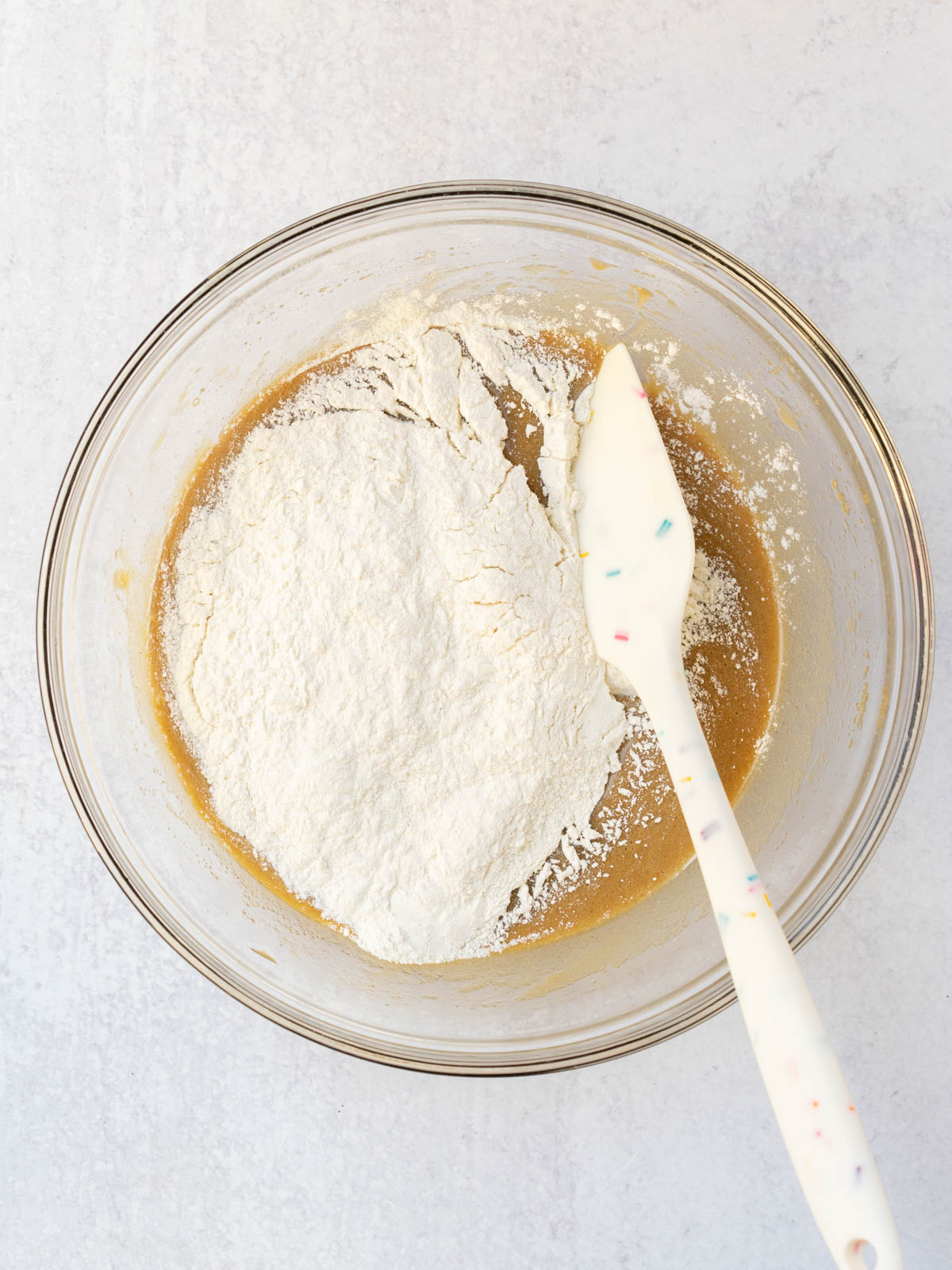 rubber spatula folding in dry ingredients to wet ingredients.