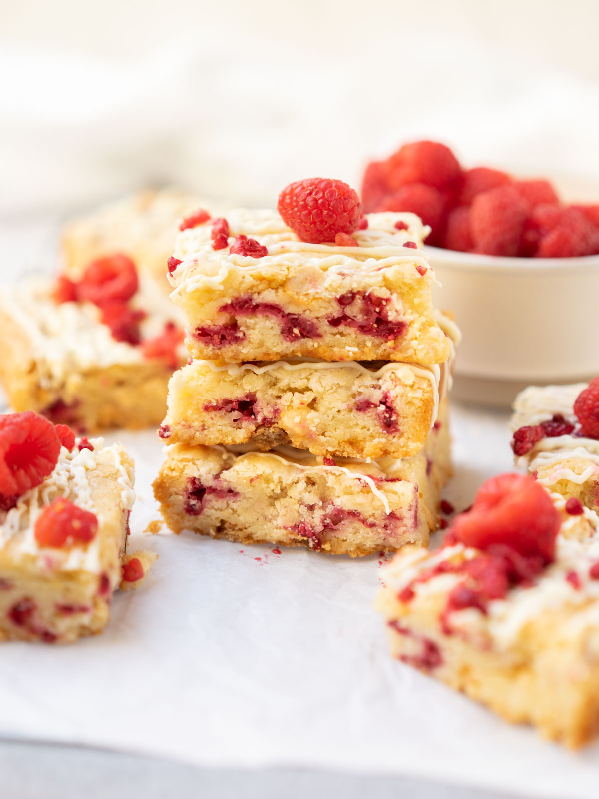 White chocolate and raspberry blondies stacked on each other.