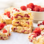 white chocolate raspberry blondies stacked on one another.