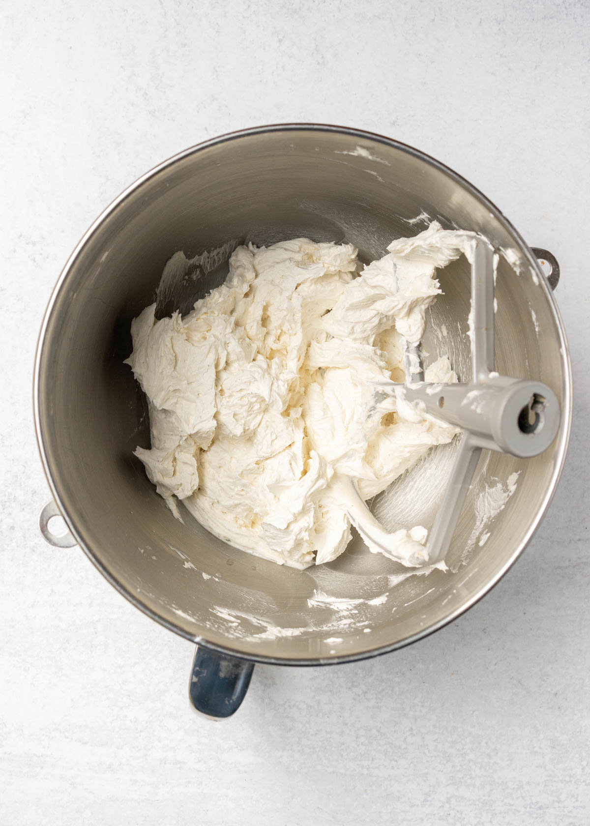 vanilla American buttercream frosting in mixing bowl with paddle attachment.