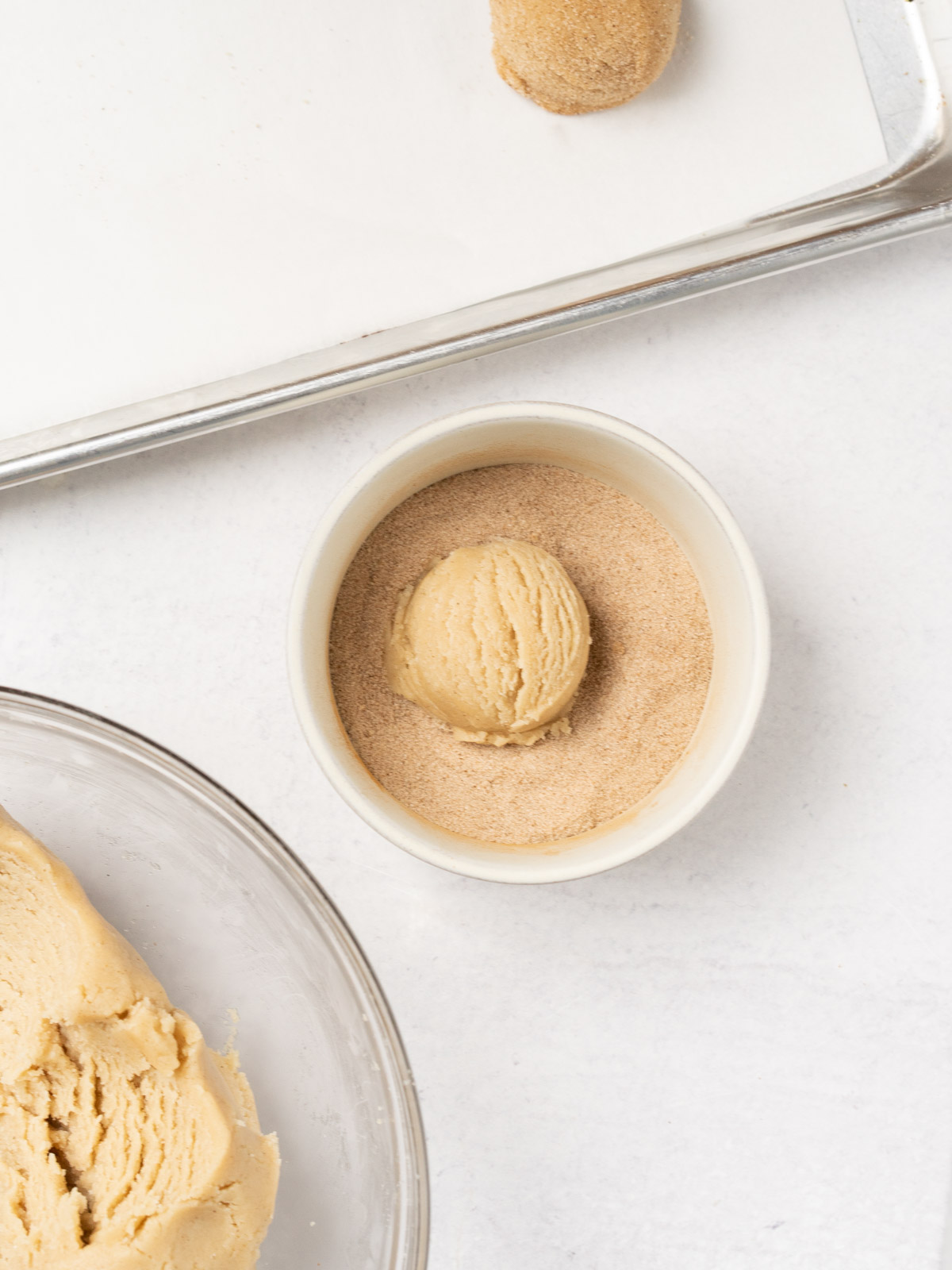 rolling cookie dough into cinnamon sugar.