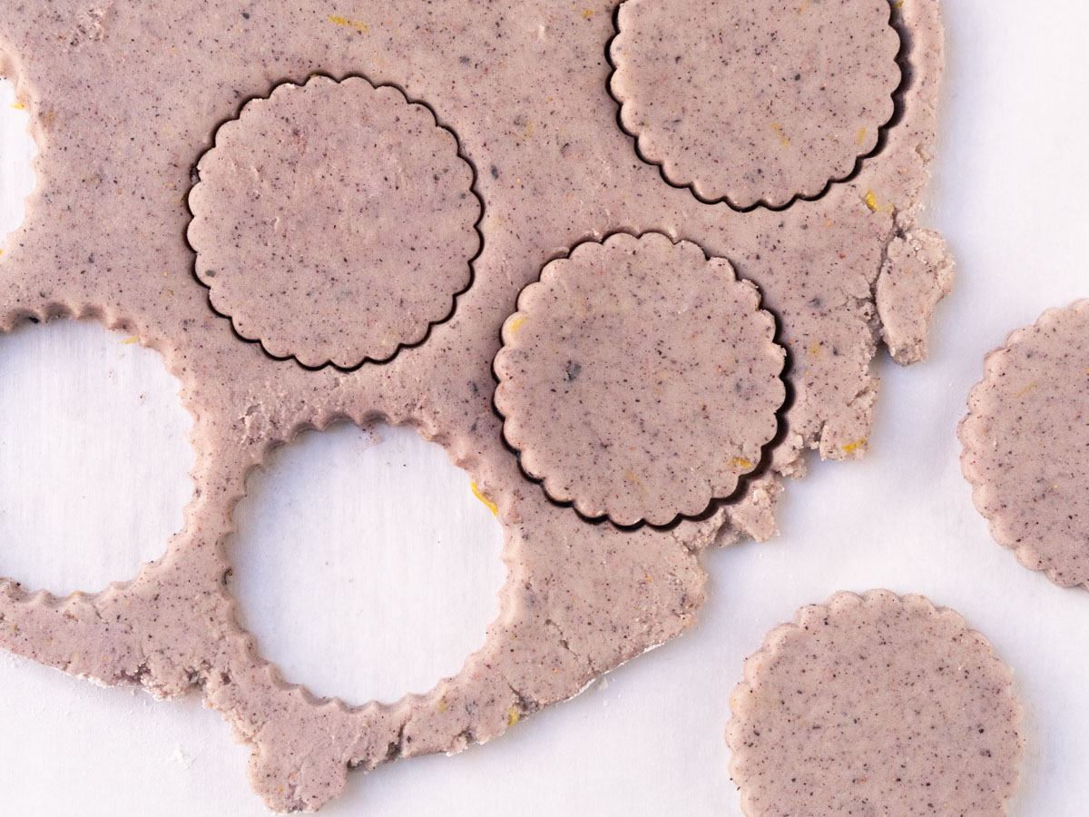 dough being cut with cookie cutters.