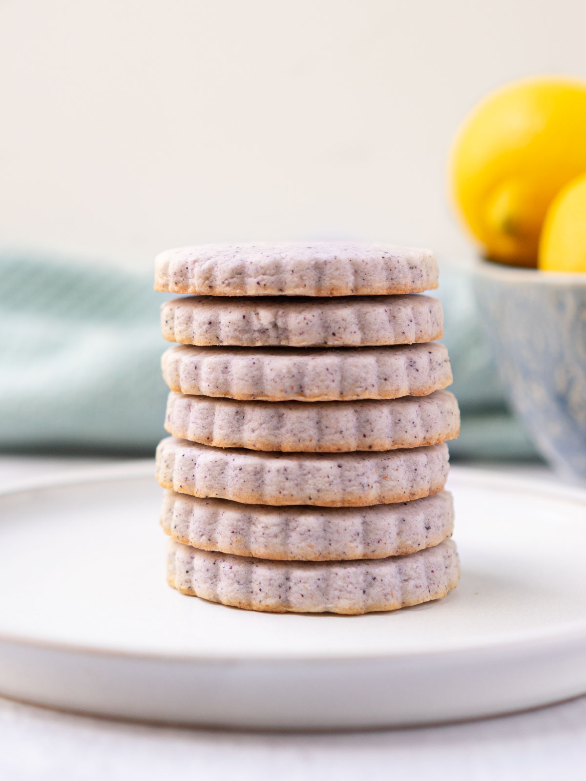 blueberry lemon sugar cookies stacked on a plate.