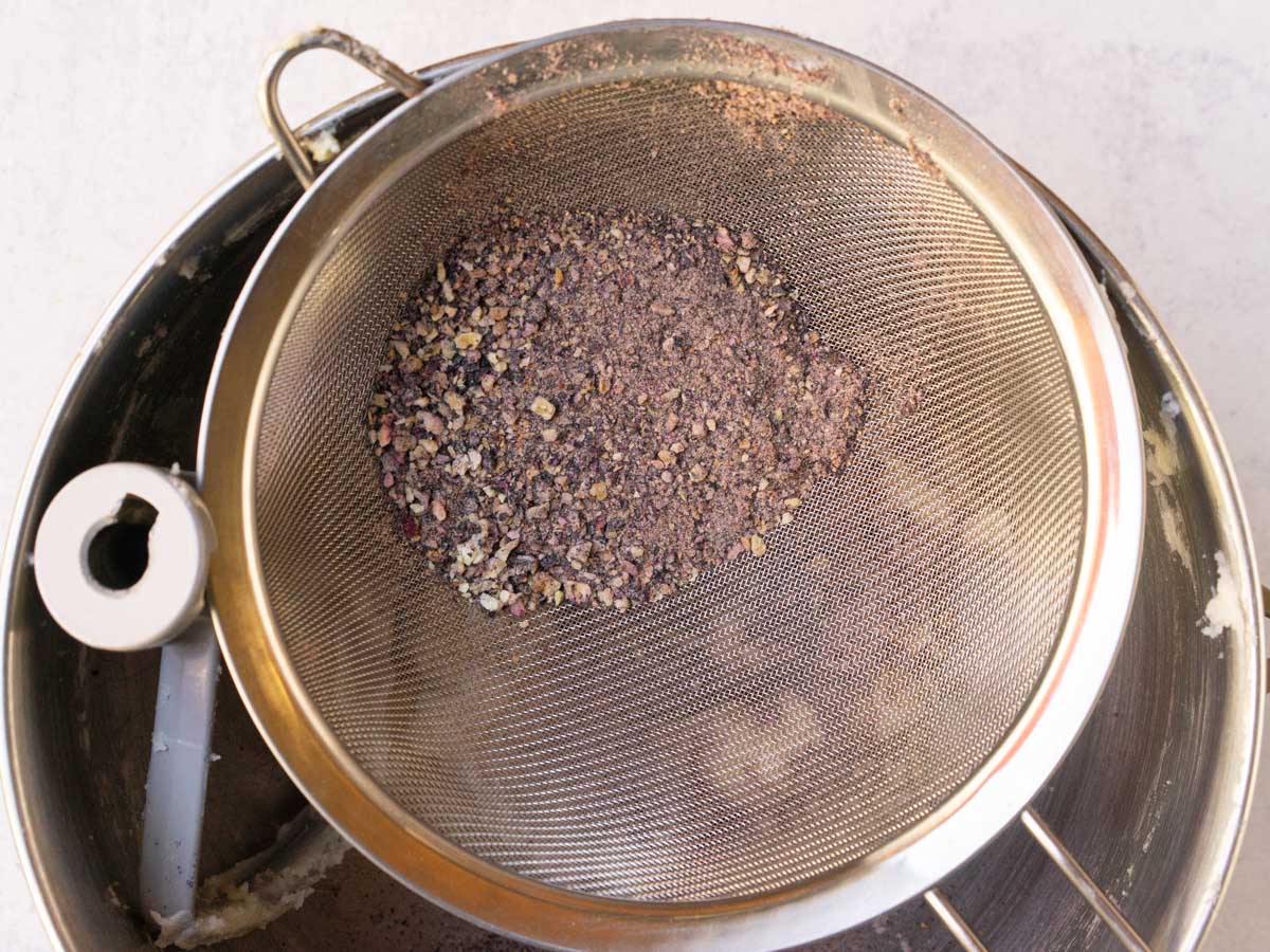 sifting powdered blueberries into mixing bowl.